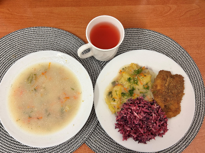 Na zdjęciu znajduje się: Jarzynowa z zacierką podstawa, Ziemniaki gotowane, Kotlet drobiowy panierowany, Sos pietruszkowy, Surówka wykwintna z olejem, Kompot owocowy, Surówka wykwintna z olejem